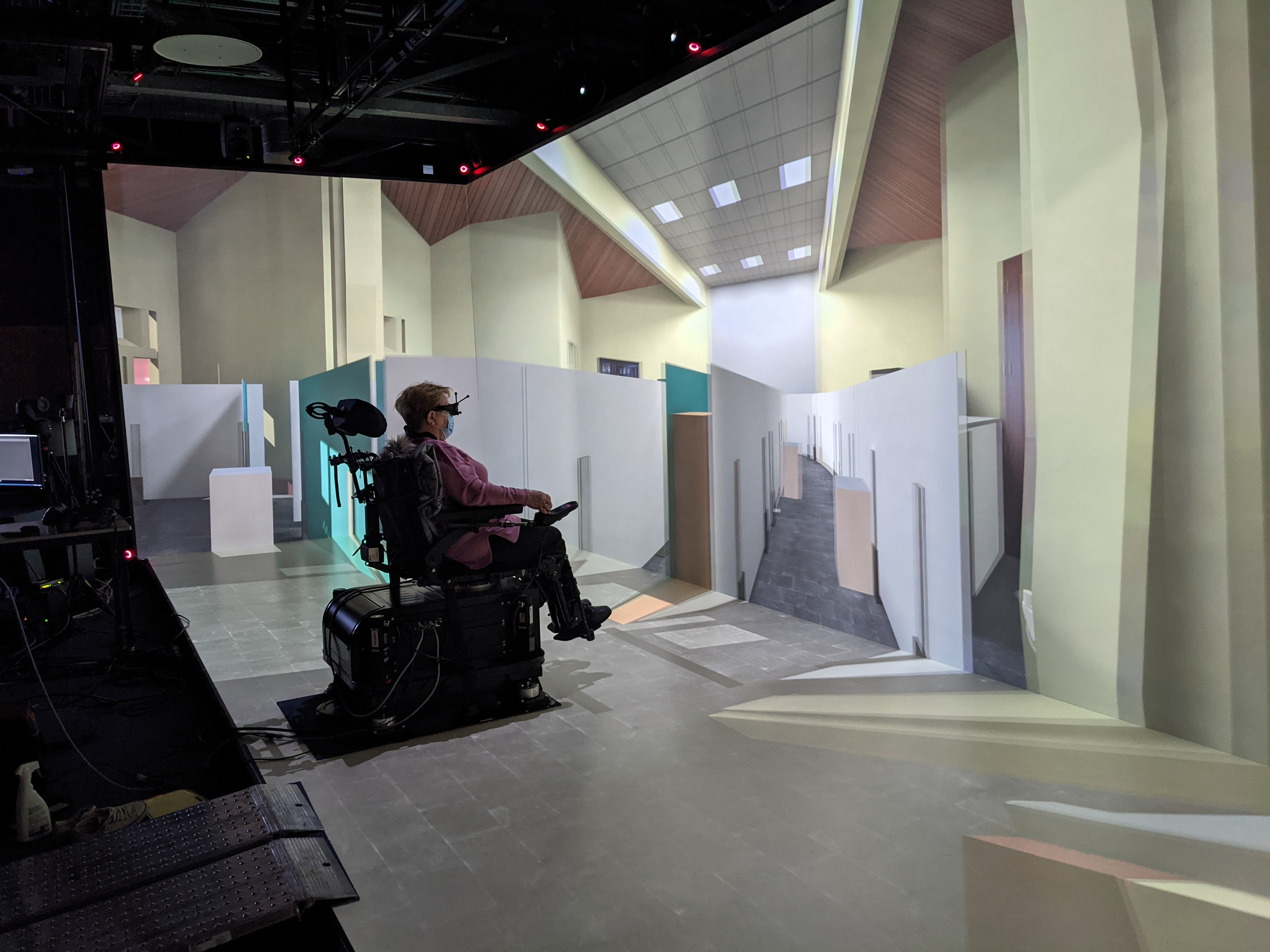 Participant driving in a virtual environment with our simulator and driving in real conditions with a real power wheelchair